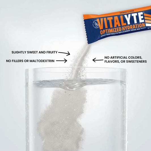 Vitalyte electrolyte powder single serving stick being poured into a glass of water.